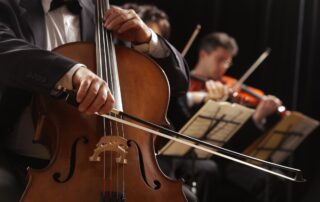 close up of cellist with violinist in background