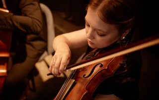 high-angle shot of female violinist playing in orchestra