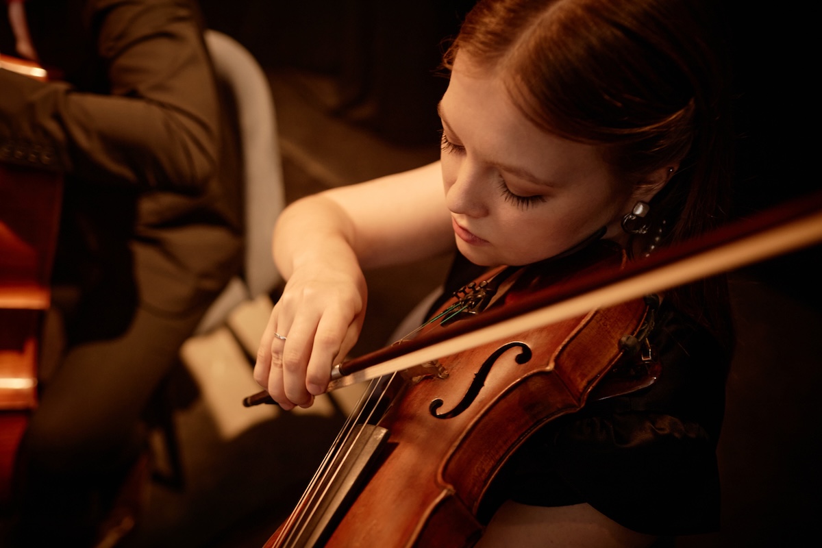 high-angle shot of female violinist playing in orchestra