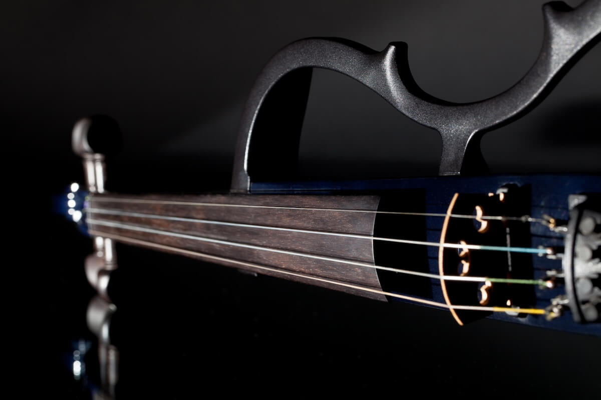 close up of an electric violin in front of a black background