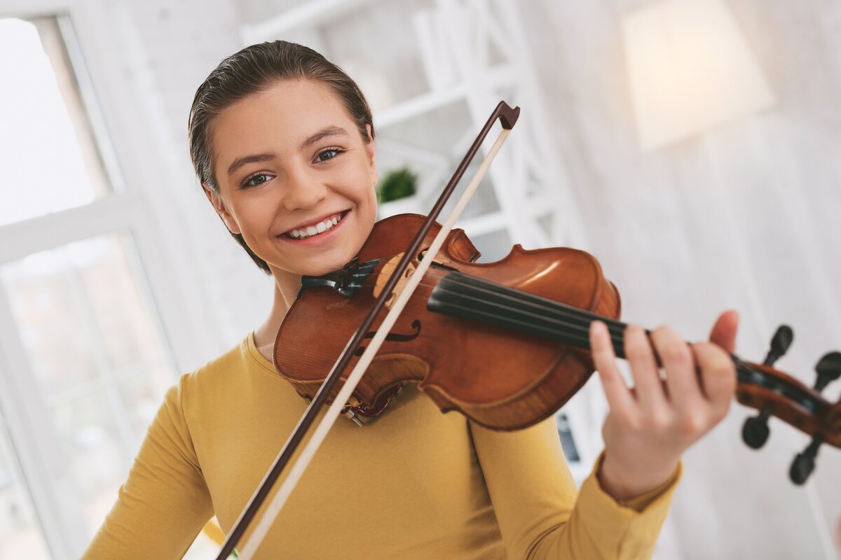 Cheerful girl playing a violin