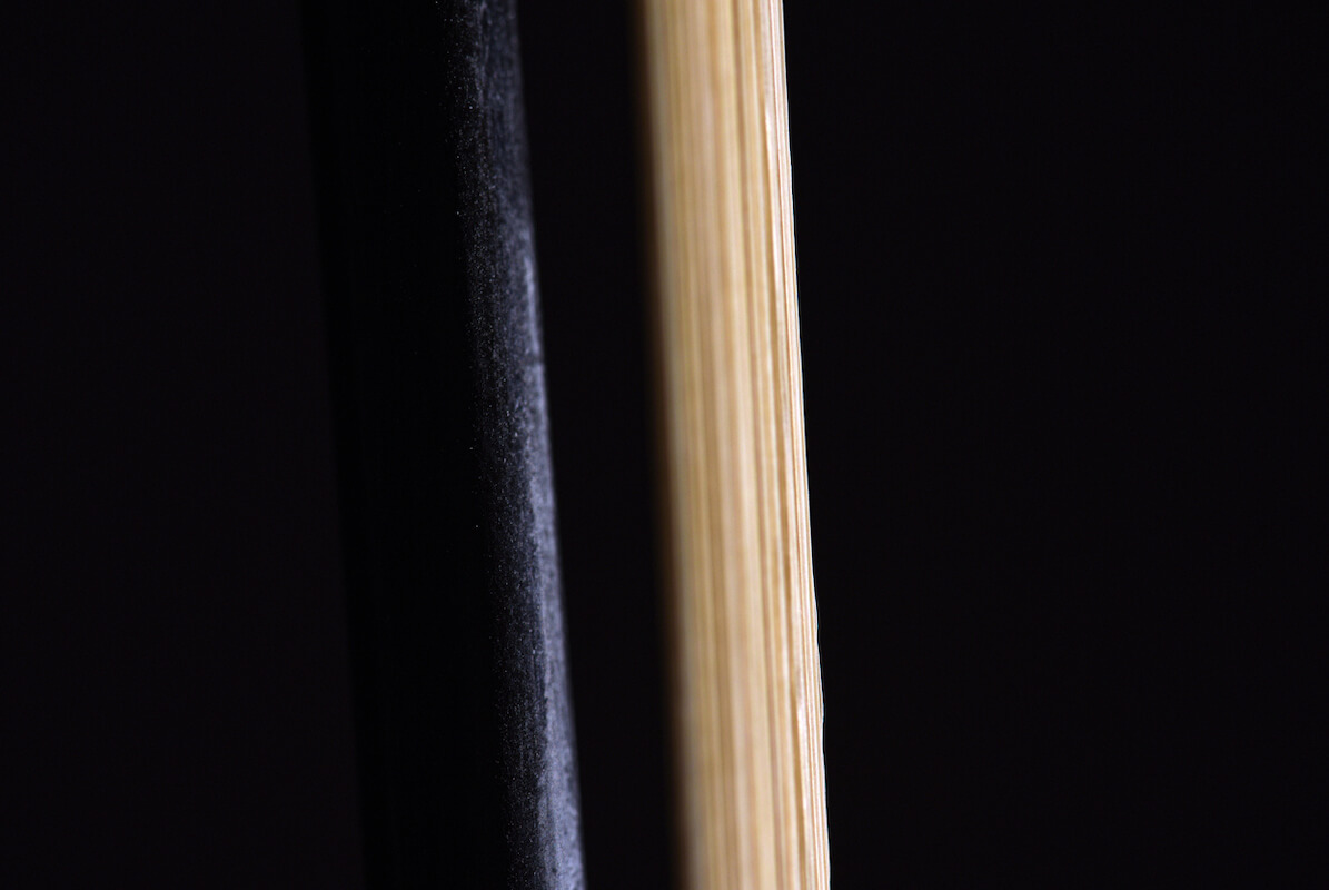 close up of the horsehair on a bow against a black background