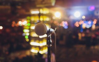 Close up microphone on stage in concert hall restaurant or conference room blurred background