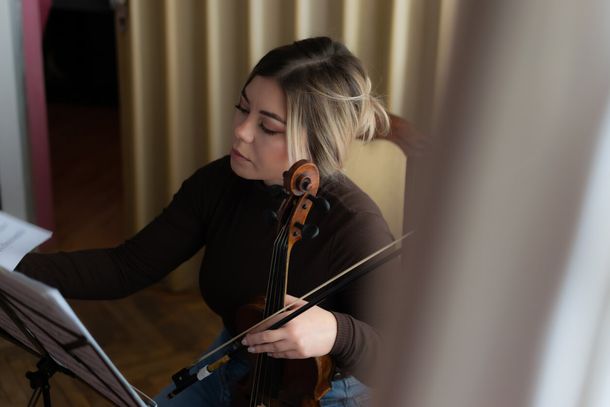 female violinist writing in a music practice journal