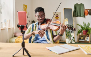 young violinist recording on his phone to post to social media later