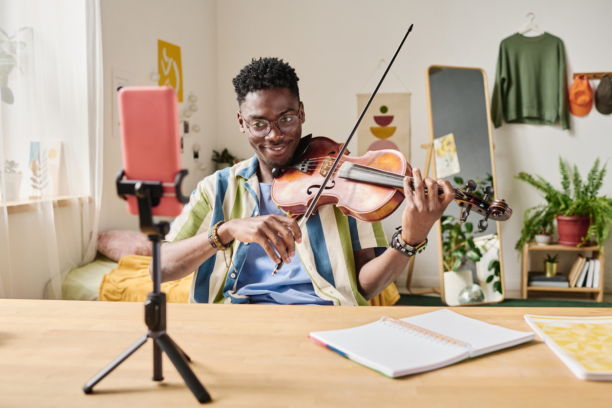 young violinist recording on his phone to post to social media later