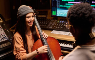 cello player talking with producer during studio session
