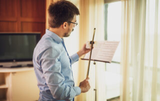 male violinist rosining his bow