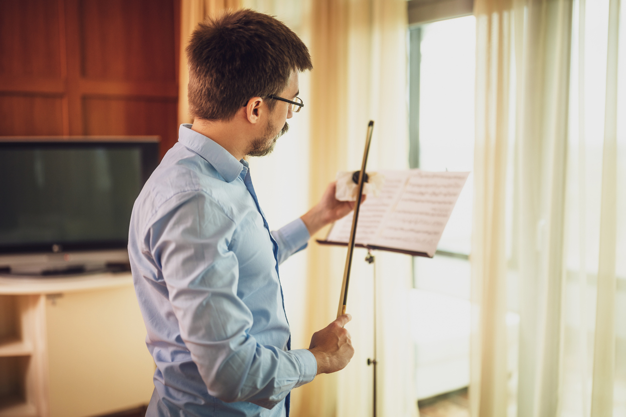 male violinist rosining his bow