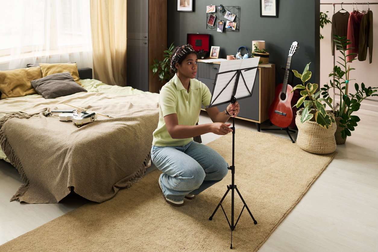 young violinist setting up a music stand in their practice space